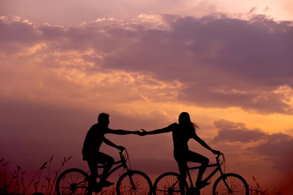 Plan Your Honeymoon in Morocco: The Ultimate Morocco Honeymoon Itinerary woman on bike reaching for man's hand behind her also on bike