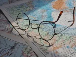 Glasses on a map with a map of the world
